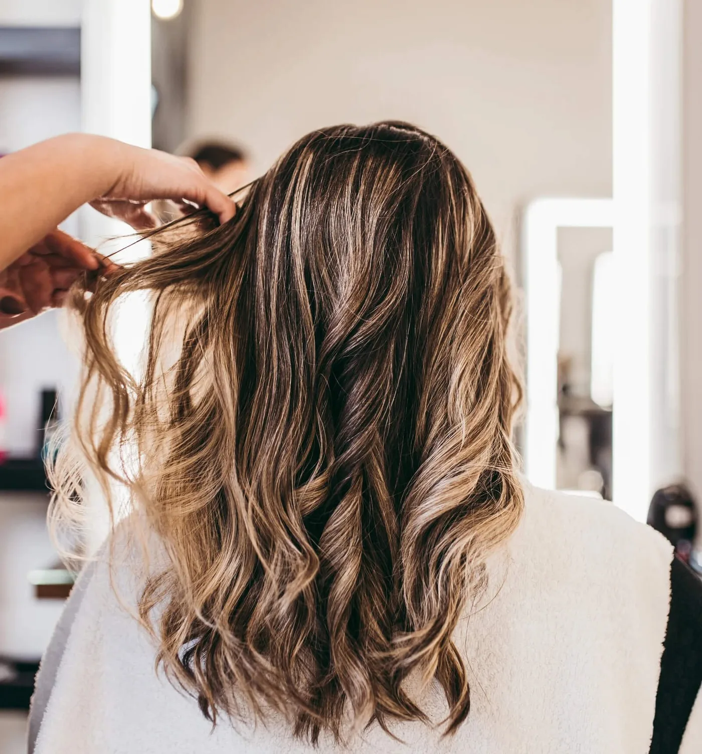 A guest enjoying an AVEDA hair service in the light-filled Salon and Spa Botanica studio